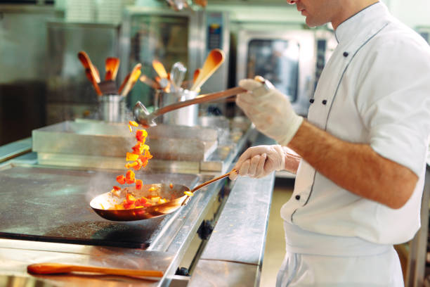 istock Chef cooking vegetables in wok pan. Shallow dof. 1271546836