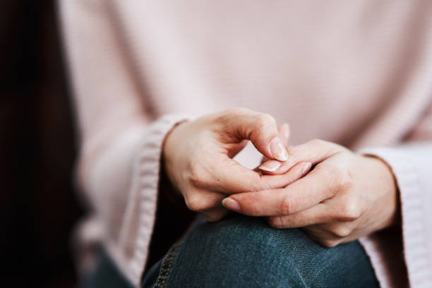 The hands say what the heart feels Cropped shot of a woman sitting on a sofa and feeling anxious victim photos stock pictures, royalty-free photos & images