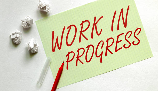 istock yellow paper with text Work In Progress on the white with red marker 1271550506
