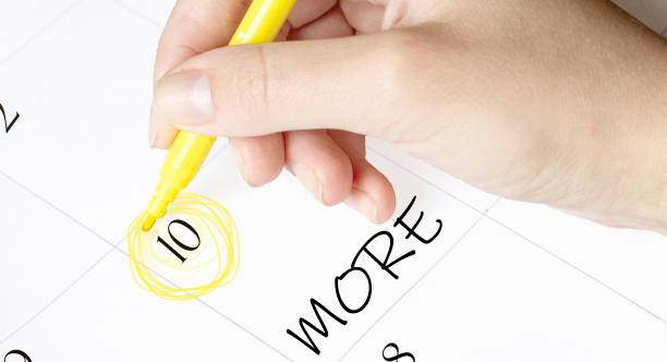 istock hand encircles a date on a calendar with text MORE yellow felt-tip pen 1271550573