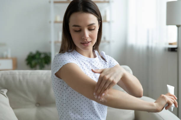 istock Smiling young woman moisturizing elbow with body cream. 1271551581