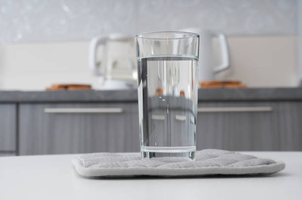 istock Glass with pure water on a kitchen interior background 1271552177