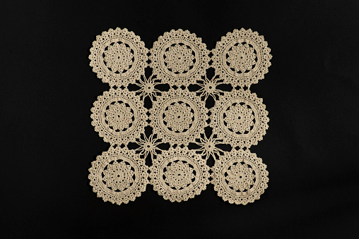 Old handmade Lace pattern background on a black background.