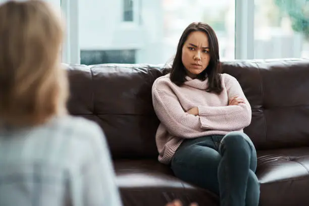 Shot of a young woman having a therapeutic session with a psychologist