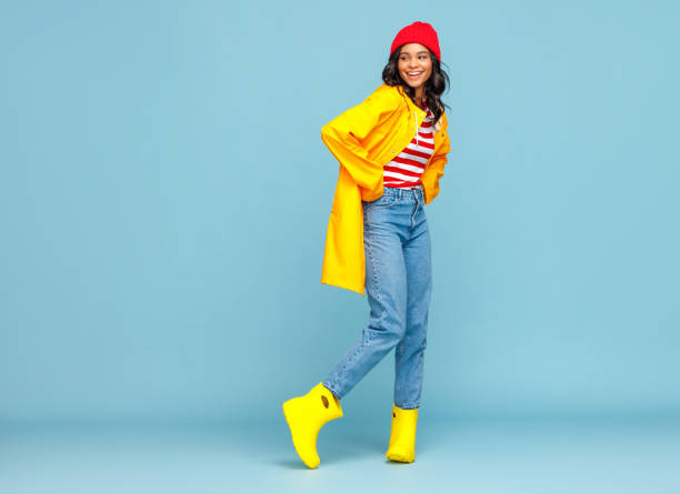 istock Happy ethnic woman in raincoat and rubber boots 1271553324