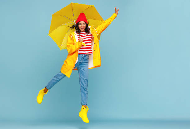 istock Happy ethnic female jumping with umbrella 1271553365