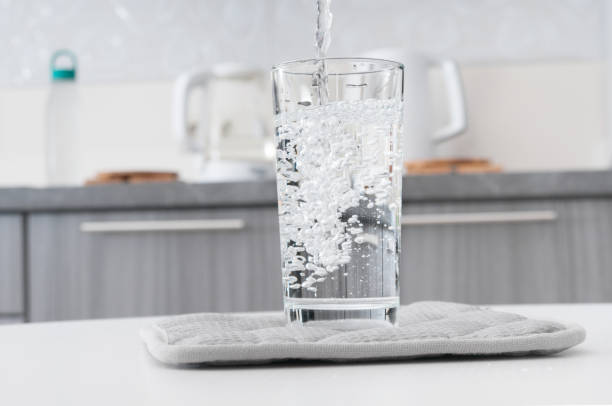 istock Pouring clean water into glass on a kitchen interior background 1271555181