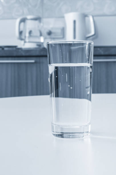 istock Water glass on a table in kitchen interior 1271555282
