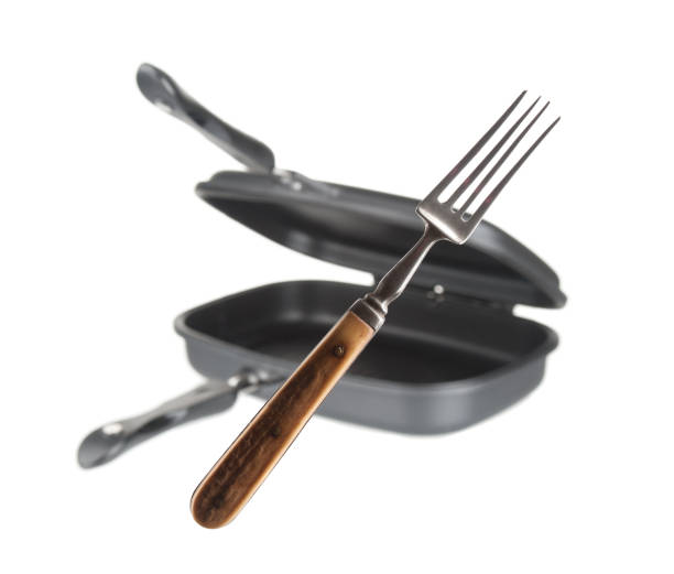istock Vintage fork and blurred double grill pan isolated on white background 1271555671