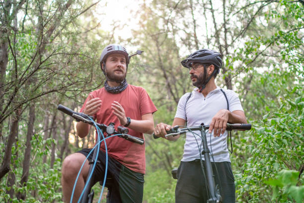 istock Two men ride a bike in the forest 1271558463