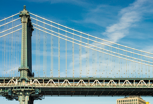A profile view of a section of the Manhattan Bridge over the East River in New York City.