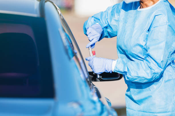 istock Unrecognizable nurse prepares coronavirus test for vehicle passenger 1271559835