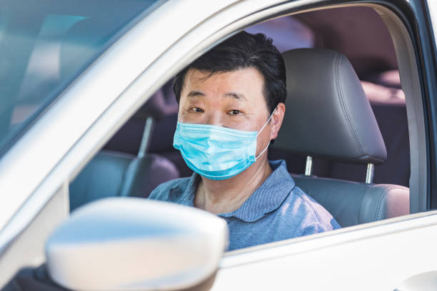 istock Worried senior man with protective mask drives car 1271559880