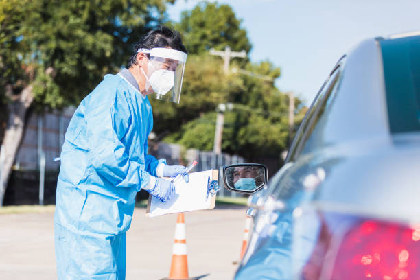 istock Nurse talks to driver of car at coronavirus testing site 1271559887