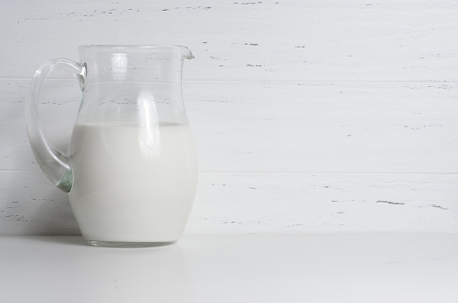 Milk in a glass jug. The concept of natural and healthy food. White background. Copy space.