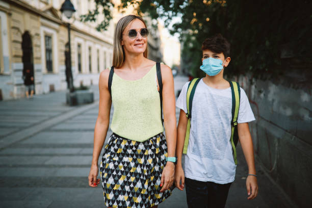 istock Mom taking her son to school during the coronavirus situation 1271561680