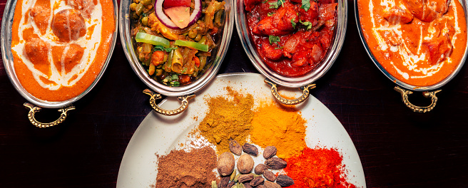 This image shows different Indian Food Selection placed of wooden table. The image is taken from top.