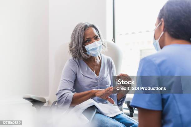 Senior Woman Talks With Female Healthcare Professional Stock Photo - Download Image Now