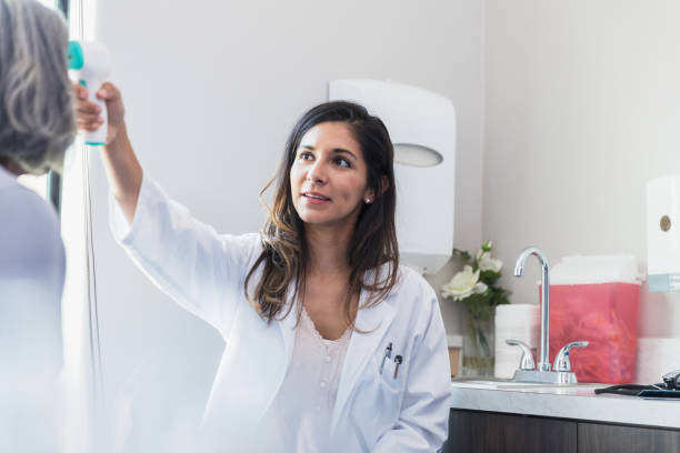 istock Doctor checking patient's temperature with infrared thermometer 1271562568