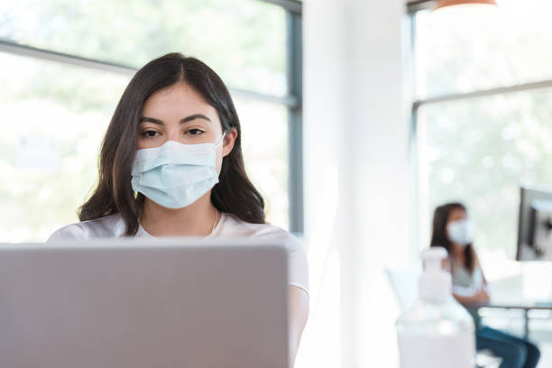istock Back to work during COVID-19, woman wears mask 1271562847