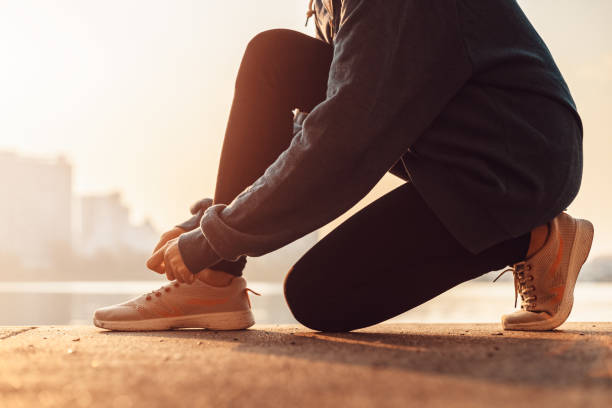 istock Woman tying shoe laces. 1271563064