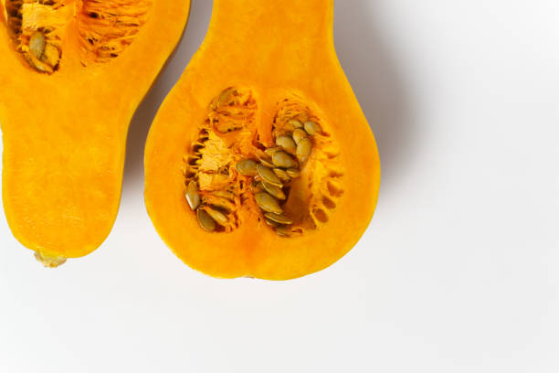 istock Sliced pumpkin with seeds and pulp on a white background. 1271563844
