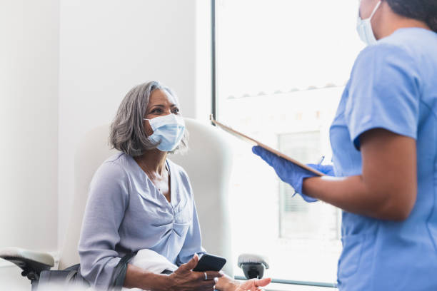 istock Confident senior woman talking with nurse 1271564159