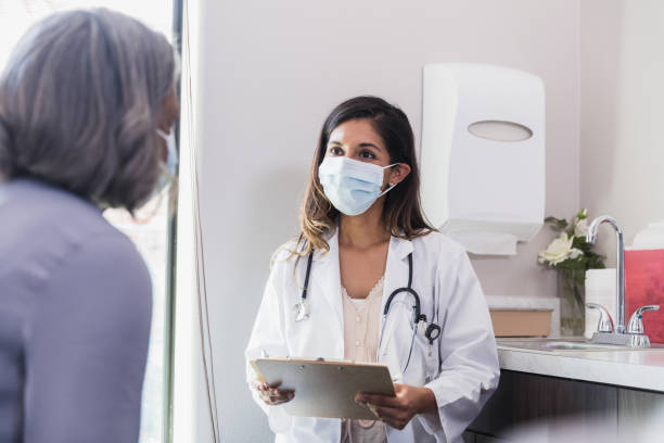 istock Doctor wears protective face mask during medical appointment 1271564726