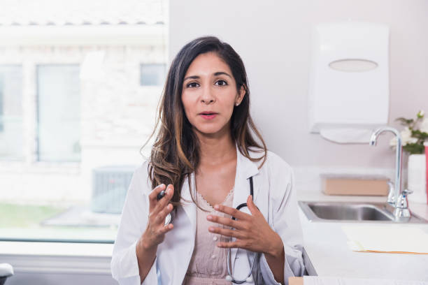 mujer médica segura habla con la cita virtual del paciente durng - explicar fotografías e imágenes de stock