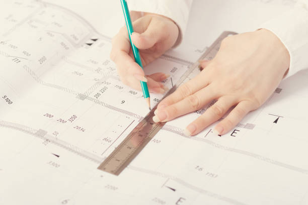 istock Architect working on blueprint, with architectural project at construction site at office desk in office 1271564976