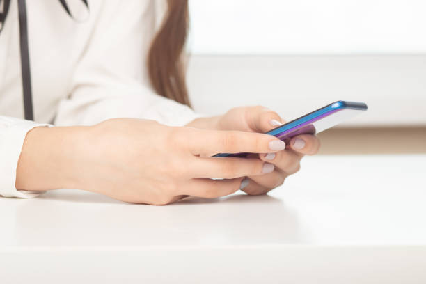 istock girl with a phone at a table typing text on the screen 1271564993