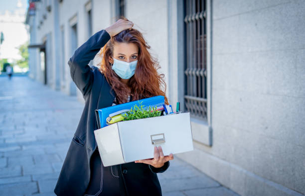 sad businesswoman in medical protective mask in business district with box of office staff feeling depressed due to job loss. coronavirus job cuts, covid-19 unemployment and economic crisis concept. - cheap finance cutting downsizing imagens e fotografias de stock