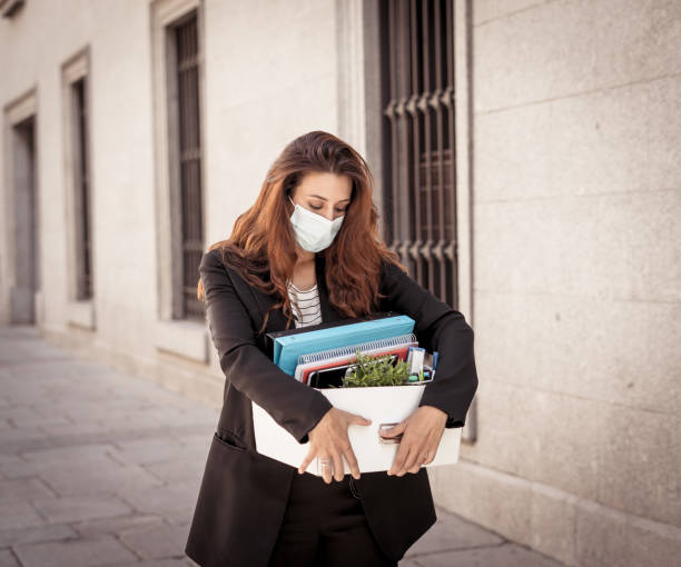 sad businesswoman in medical protective mask in business district with box of office staff feeling depressed due to job loss. coronavirus job cuts, covid-19 unemployment and economic crisis concept. - cheap finance cutting downsizing imagens e fotografias de stock