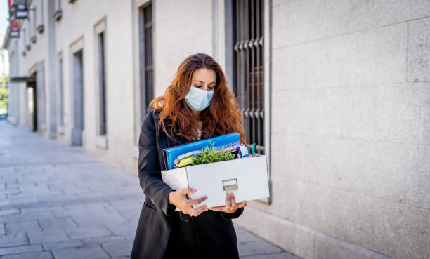 sad businesswoman in medical protective mask in business district with box of office staff feeling depressed due to job loss. coronavirus job cuts, covid-19 unemployment and economic crisis concept. - cheap finance cutting downsizing imagens e fotografias de stock