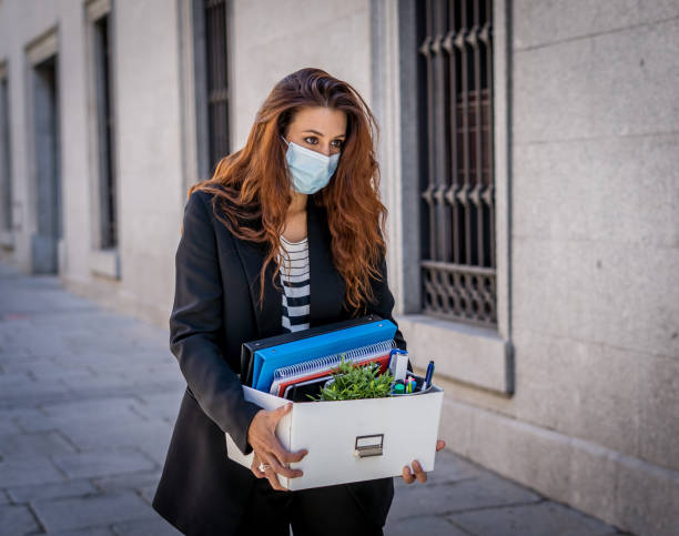 sad businesswoman in medical protective mask in business district with box of office staff feeling depressed due to job loss. coronavirus job cuts, covid-19 unemployment and economic crisis concept. - cheap finance cutting downsizing imagens e fotografias de stock