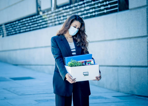 sad businesswoman in medical protective mask in business district with box of office staff feeling depressed due to job loss. coronavirus job cuts, covid-19 unemployment and economic crisis concept. - cheap finance cutting downsizing imagens e fotografias de stock