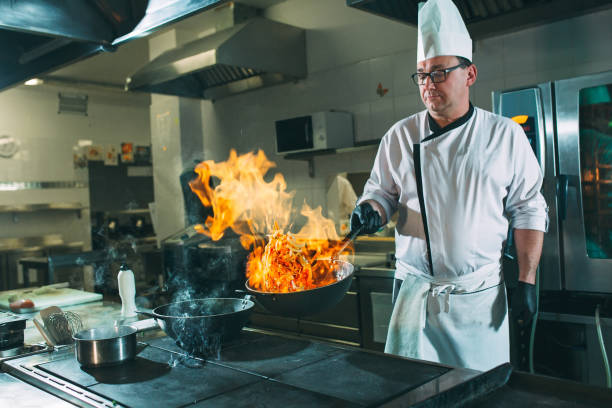 istock Chef is stirring vegetables in work on the kitchen. 1271568000