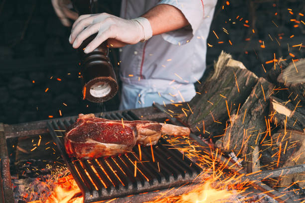 istock Chef Cooking steak. Cook turns the meat on the fire. 1271568200