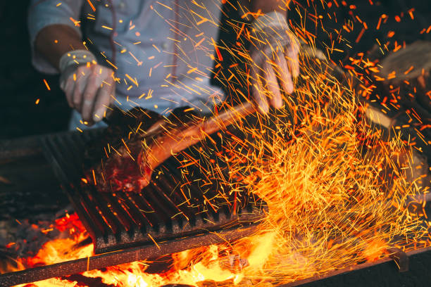 istock Chef Cooking steak. Cook turns the meat on the fire. 1271568220