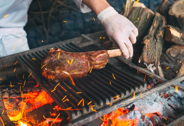 istock Chef Cooking steak. Cook turns the meat on the fire. 1271568232
