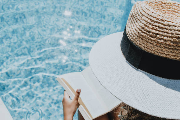 istock Woman with hat  reading a book 1271568385