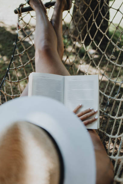 A short hair mature woman is using her smartphone interrupting her book reading