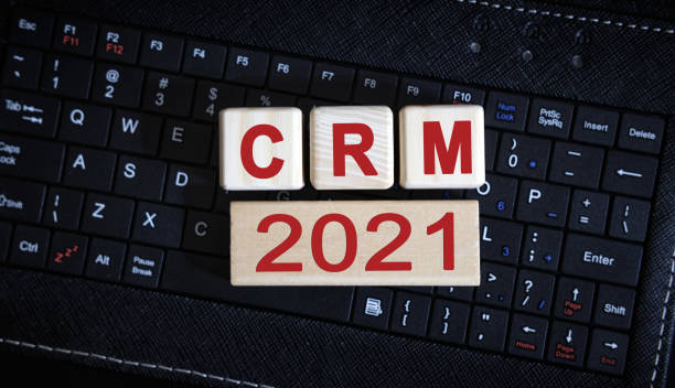 istock CRM 2021 concept. Wooden cubes on a black keyboard 1271571166