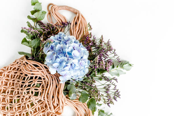 istock Beautiful bouquet of hydrangeas in a string, eco bag on white background. Flat lay, top view 1271572345