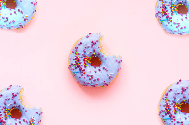 istock Colored donuts  with colorful sprinkles on pink background. National Donut or Doughnut day concept. 1271576743