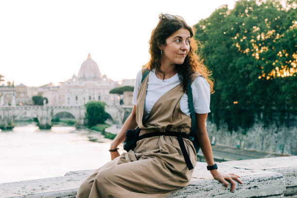 портрет молодой взрослой красивой женщины, сидящей на мосту в риме, италия - cupola people rome lazio стоковые фото и изображения