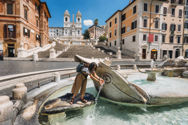 jeune femme se rafraîchir dans fontana della barcaccia - piazza di spagna square à rome, italie - piazza di spagna spanish steps church trinita dei monti photos et images de collection