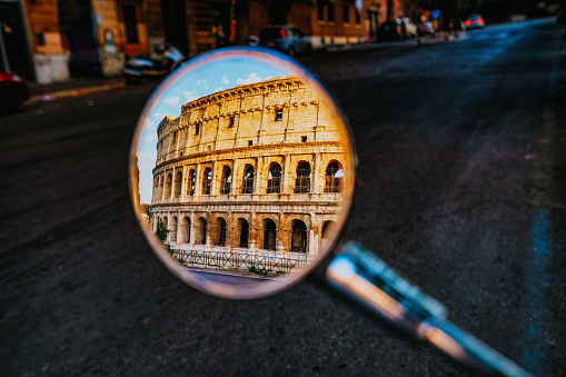 Coliseum in Rome reflected in the rearview mirror of a motor scooter. Sunrise in Rome, Italy.