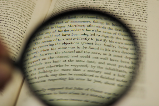 A magnified close up of a page from a text book with the use of a magnifying glass lens
