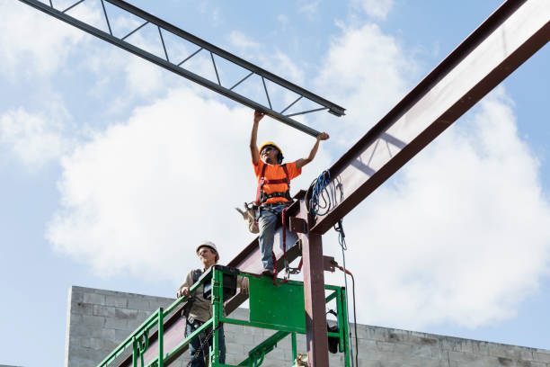 Ironworkers at construction site installing roof joist